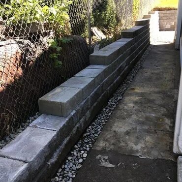 Step down retaining wall installation at residence.
